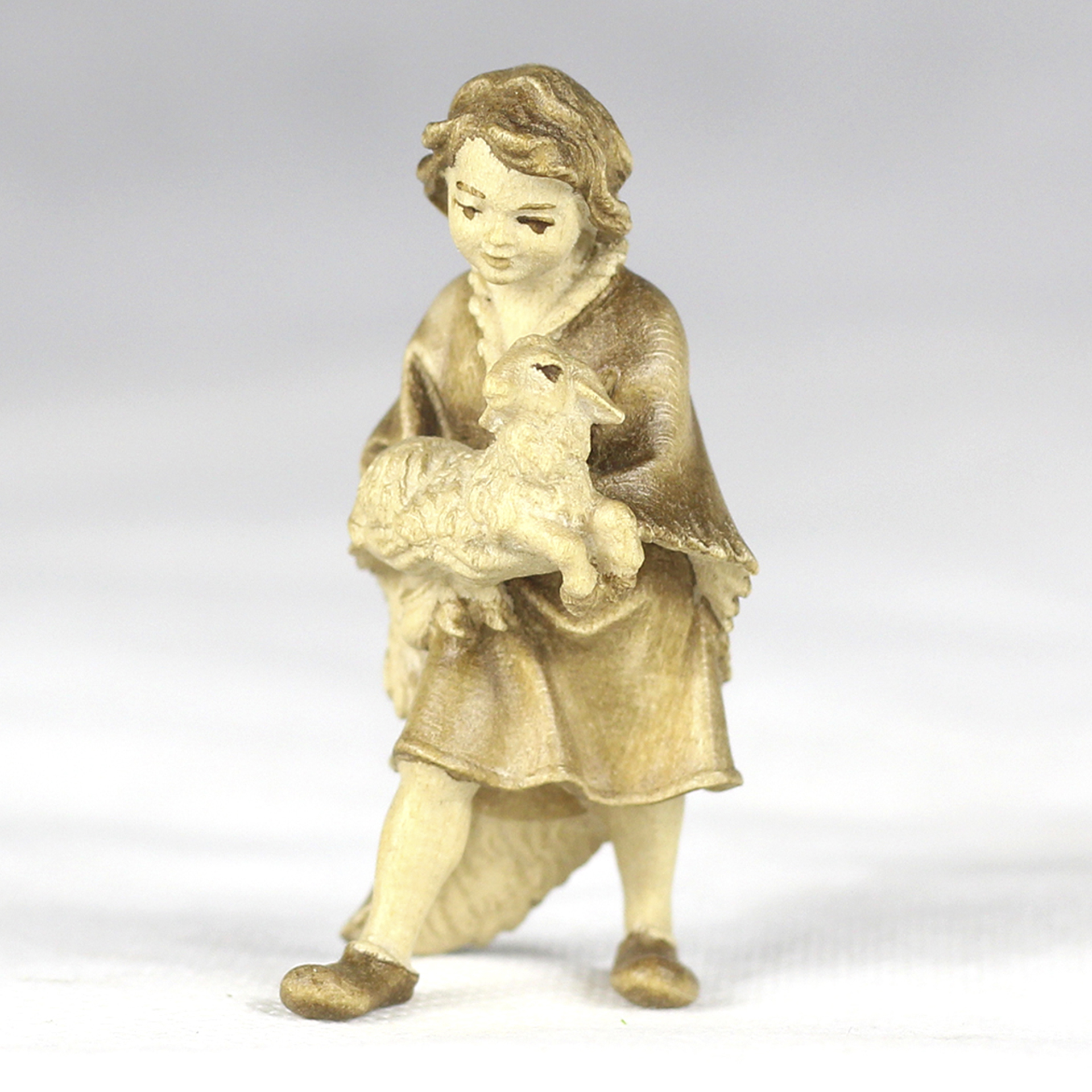 Junge trägt Lamm auf dem Arm